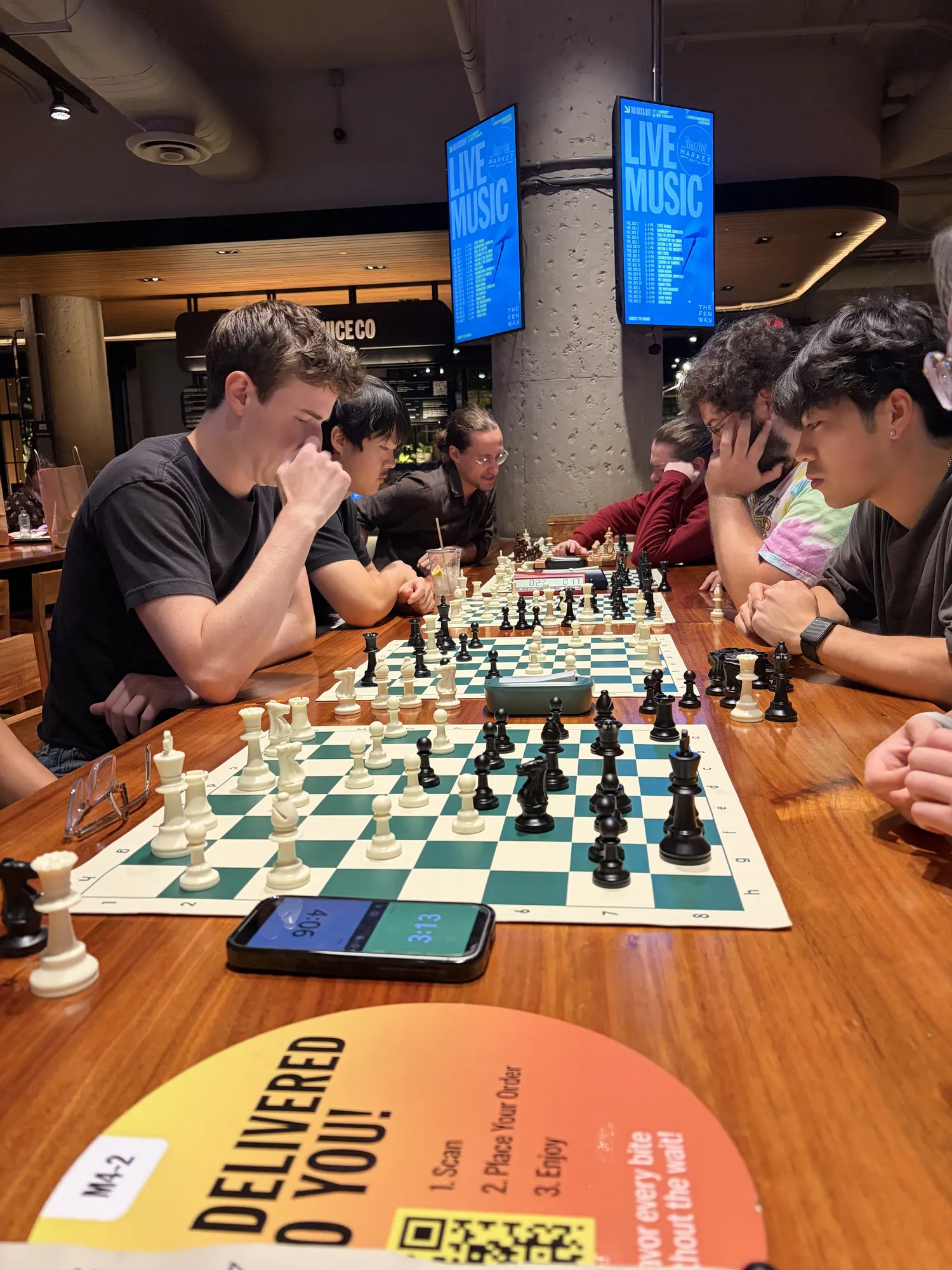 A player laughs over a mid-game board on a wooden bar table