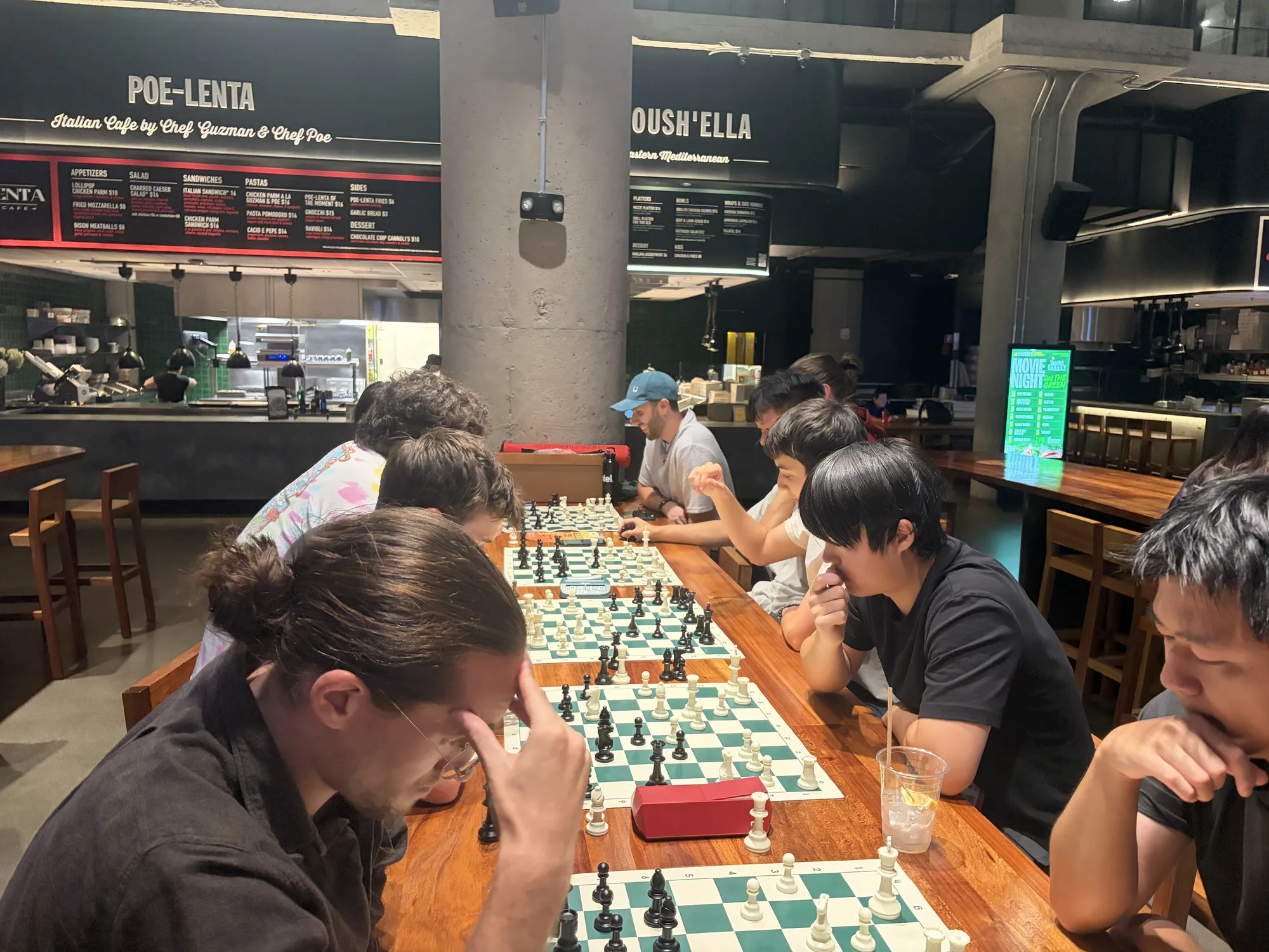 A player rests their head in one hand, deep in thought, along a row of games