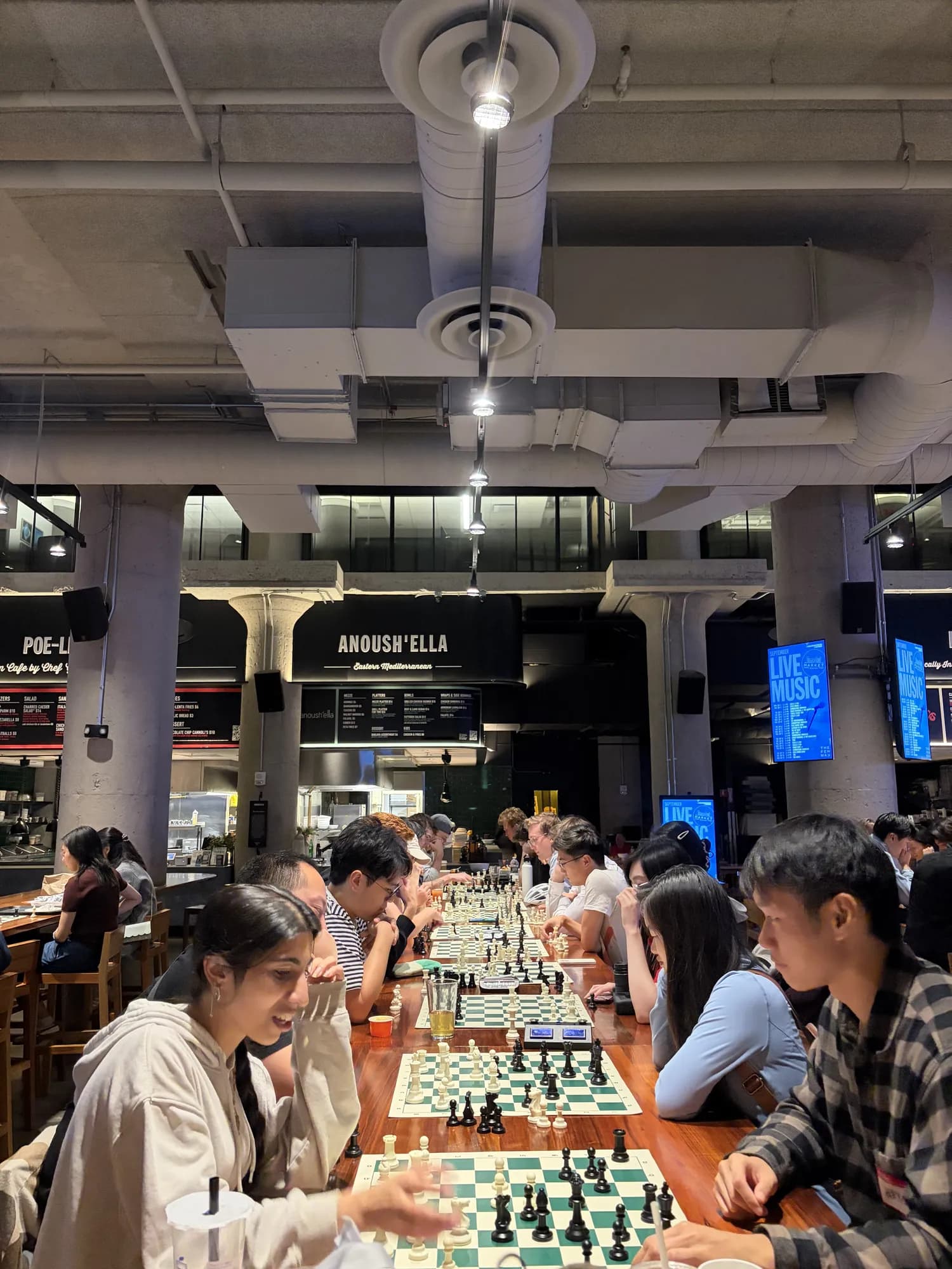 Rows of players at long tables under the food hall's pendant lights