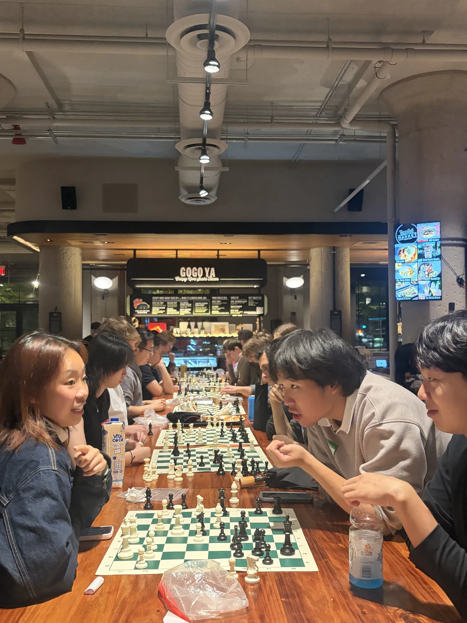 One player laughs as the other leans in over the board